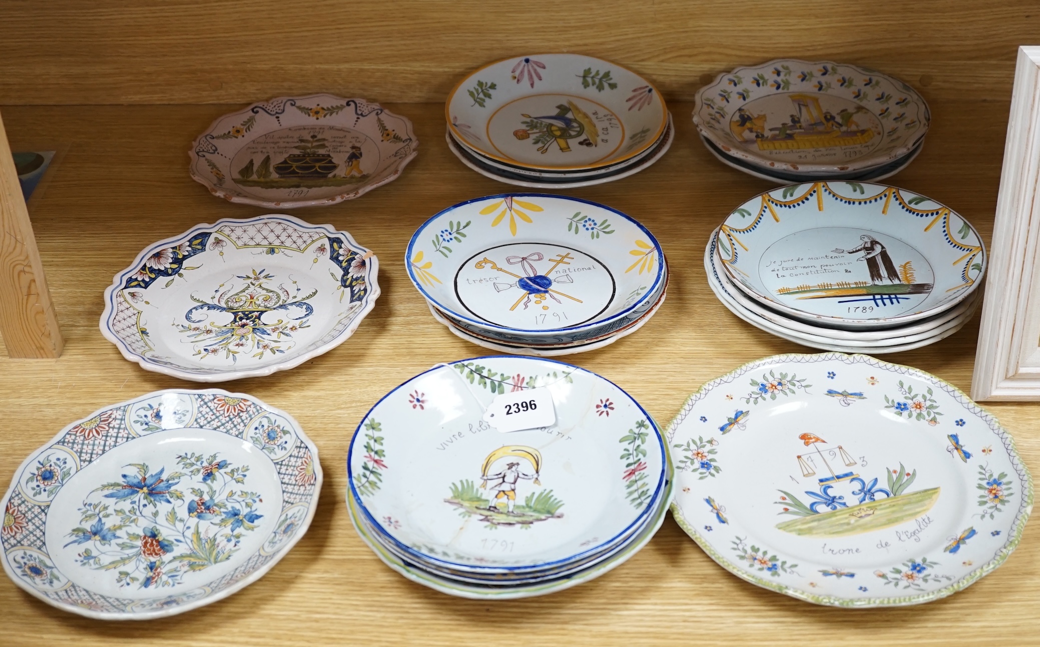 A collection of twenty 18th/19th century French faience polychrome and blue and white Revolution commemorative plates and three others, largest 27cm diameter (23)